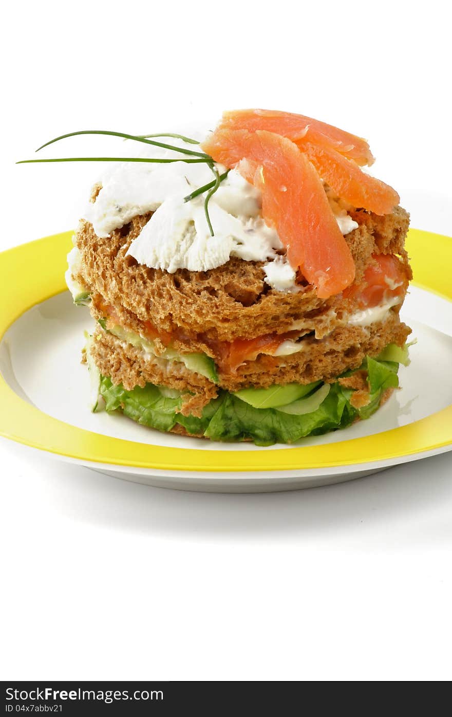 Big Tasty Sandwich with Salmon, Greens, Spring Onion and Cream Cheese on Yellow Plate closeup