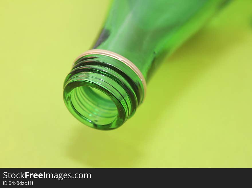 Mouth of green bottle over green background