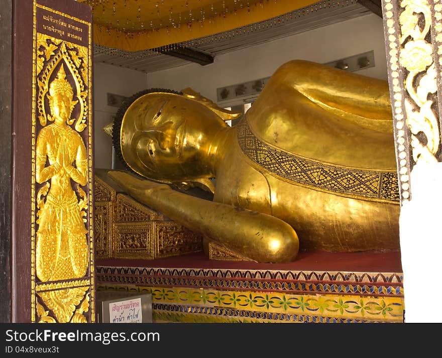 The Big golden Reclining Buddha in the important temple in Phrae, Thailand.