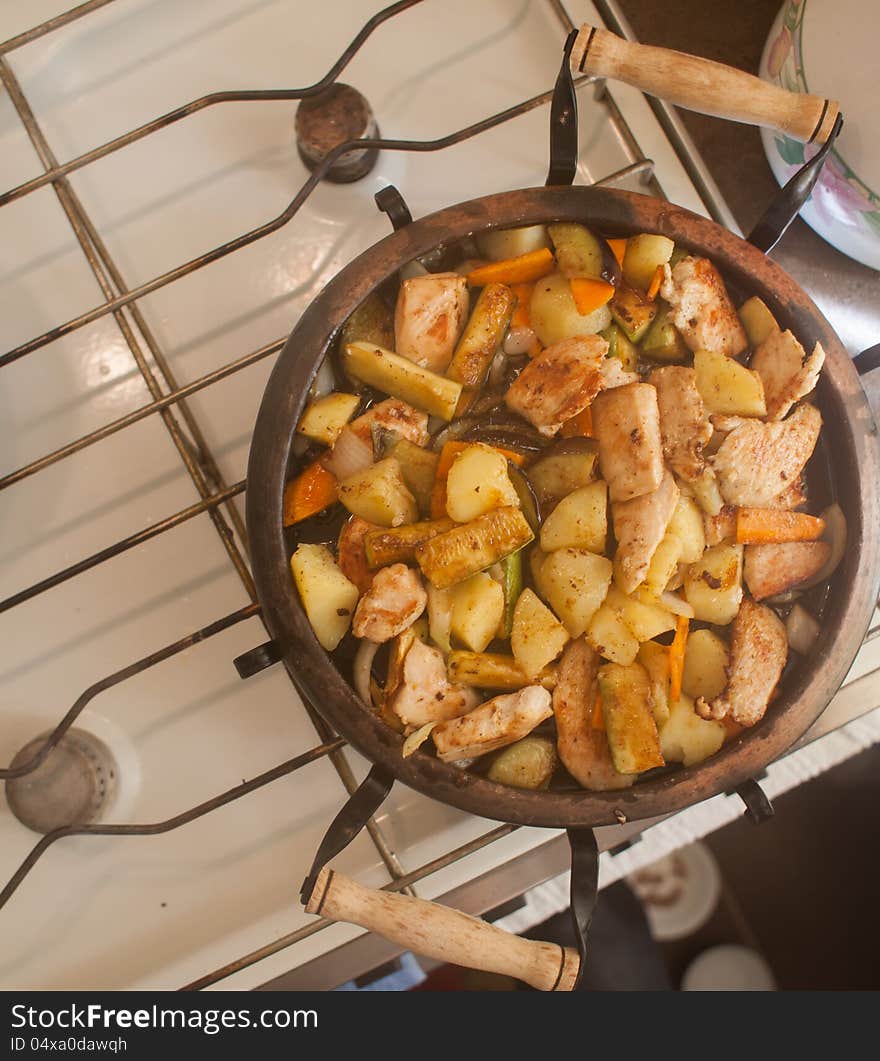 A dish made of potatoes, meat and vegetables cooked on a clay plate. A dish made of potatoes, meat and vegetables cooked on a clay plate