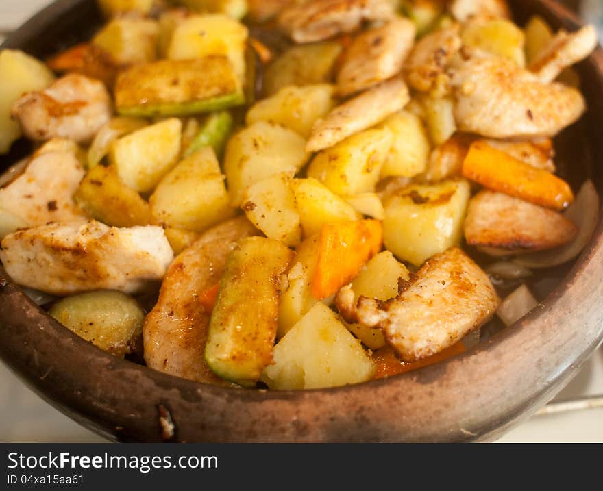 A dish made of potatoes, meat and vegetables cooked on a clay plate. A dish made of potatoes, meat and vegetables cooked on a clay plate