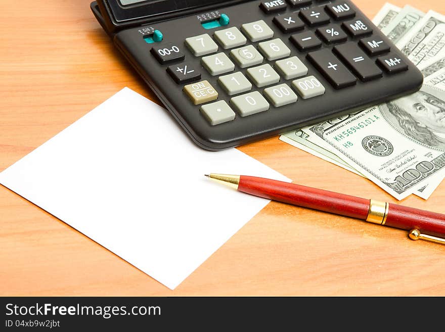 Pen, calculator and money close up.