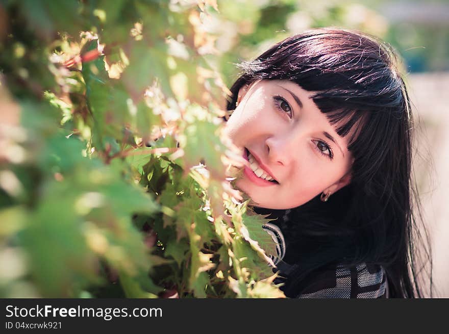 Young woman standing near a maple