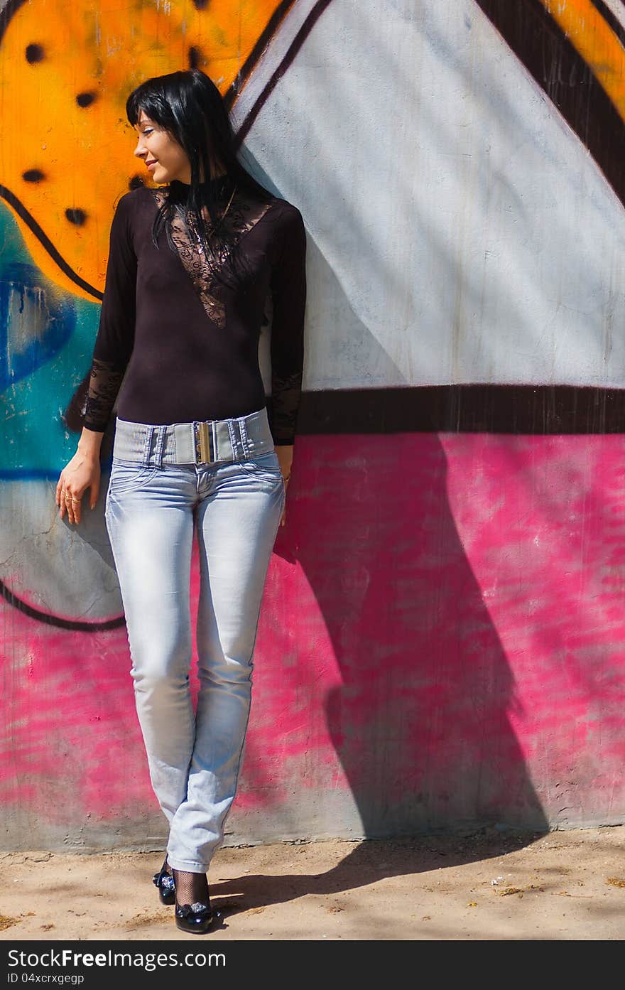 Portrait of young woman against a wall with graffiti. Portrait of young woman against a wall with graffiti