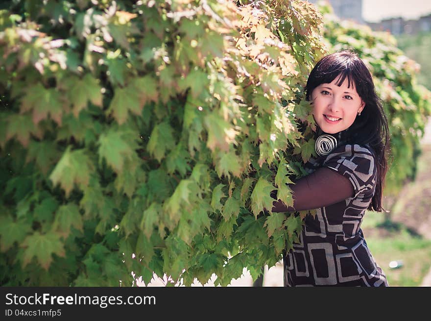 Young woman standing near a maple