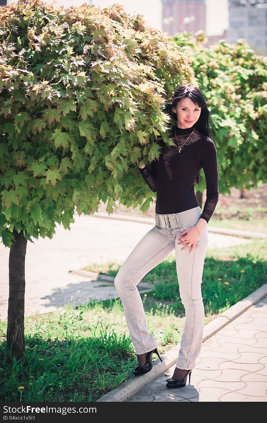 Young woman standing near a maple