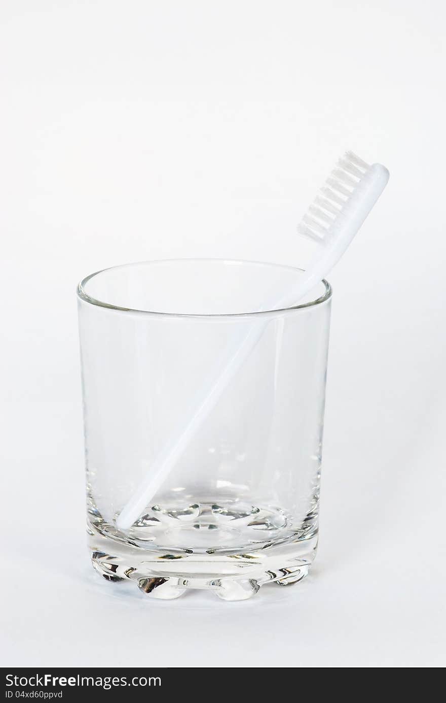 Toothbrush in a glass beaker on a white background. Toothbrush in a glass beaker on a white background