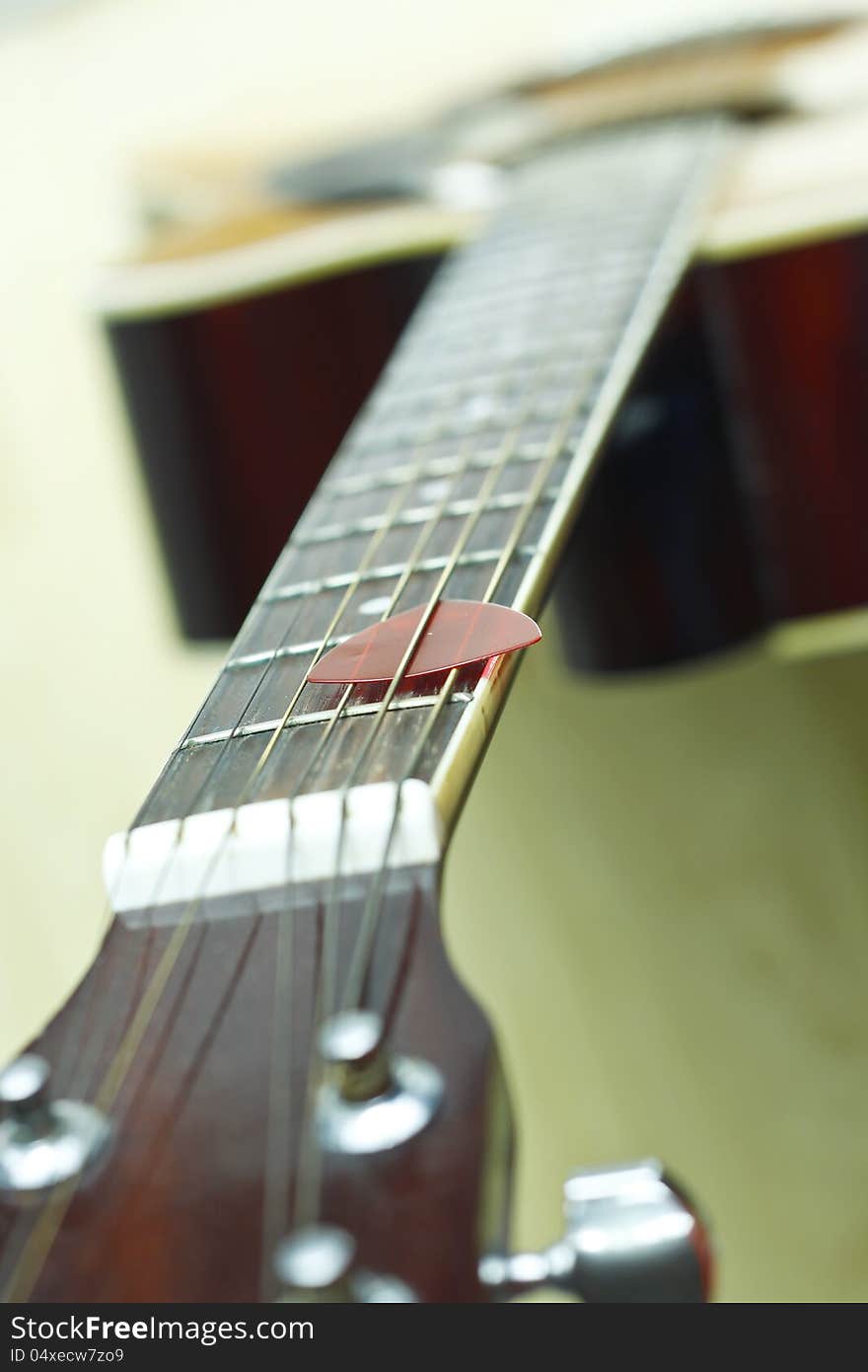 Focus at Red guitar pick on the fingerboard