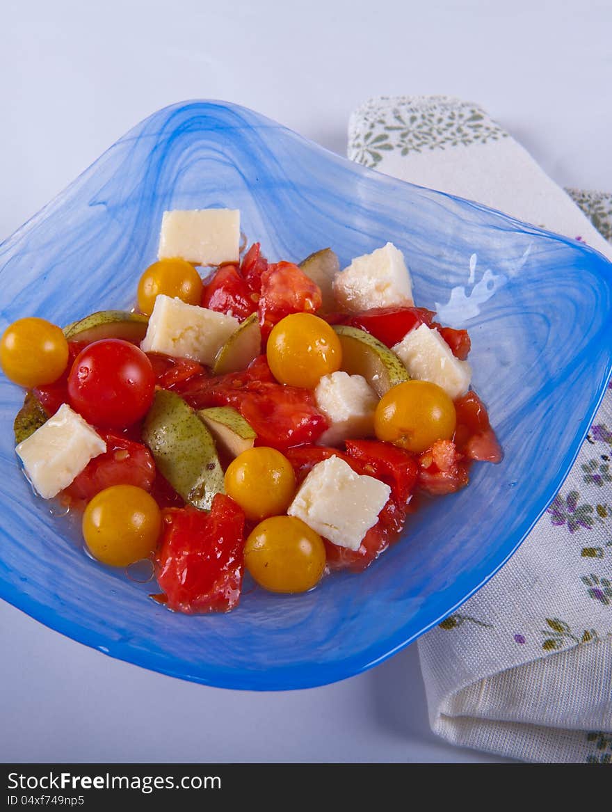 Red and yellow tomatoes with pears and cheese salad. Red and yellow tomatoes with pears and cheese salad