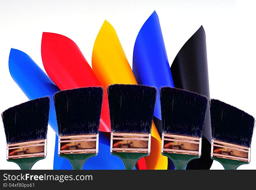 Rolls of colored sheets and five brushes in their background all photographed on a white sheet. Rolls of colored sheets and five brushes in their background all photographed on a white sheet