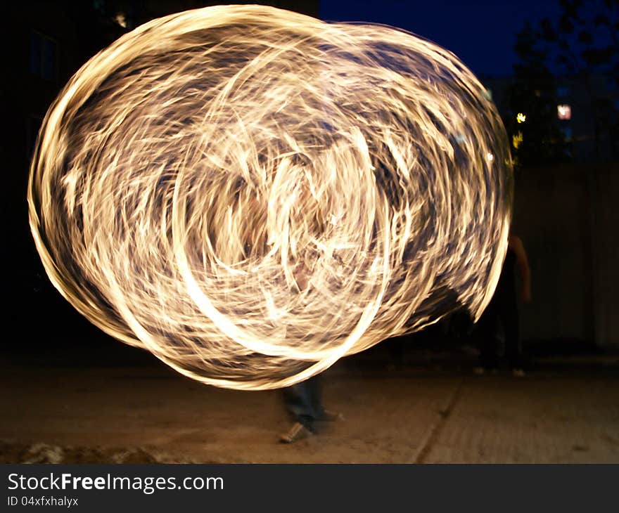 Fire dancer creating beautiful fire loops . Fire dancer creating beautiful fire loops .