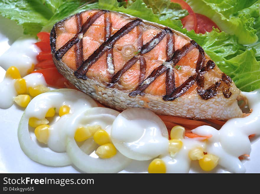 Grilled salmon steak with salad