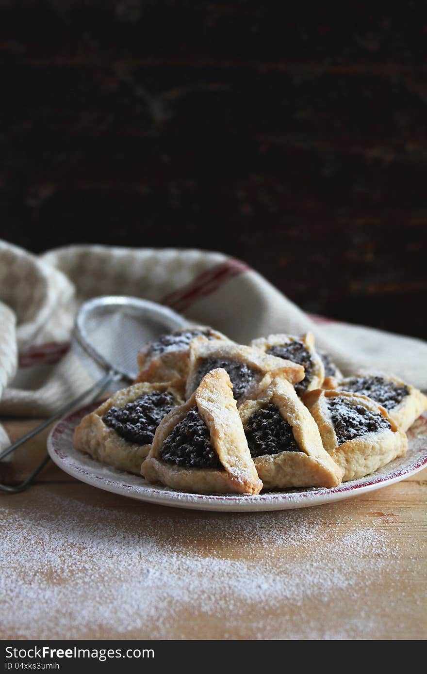 Cookies with date and poppy seed filling on a plate for a Jewish holiday Purim