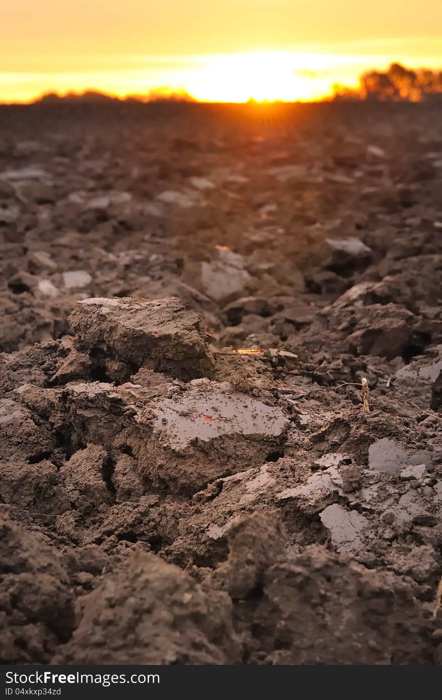 Field of freshly turned topsoil forming clods of earth at twilight. Field of freshly turned topsoil forming clods of earth at twilight