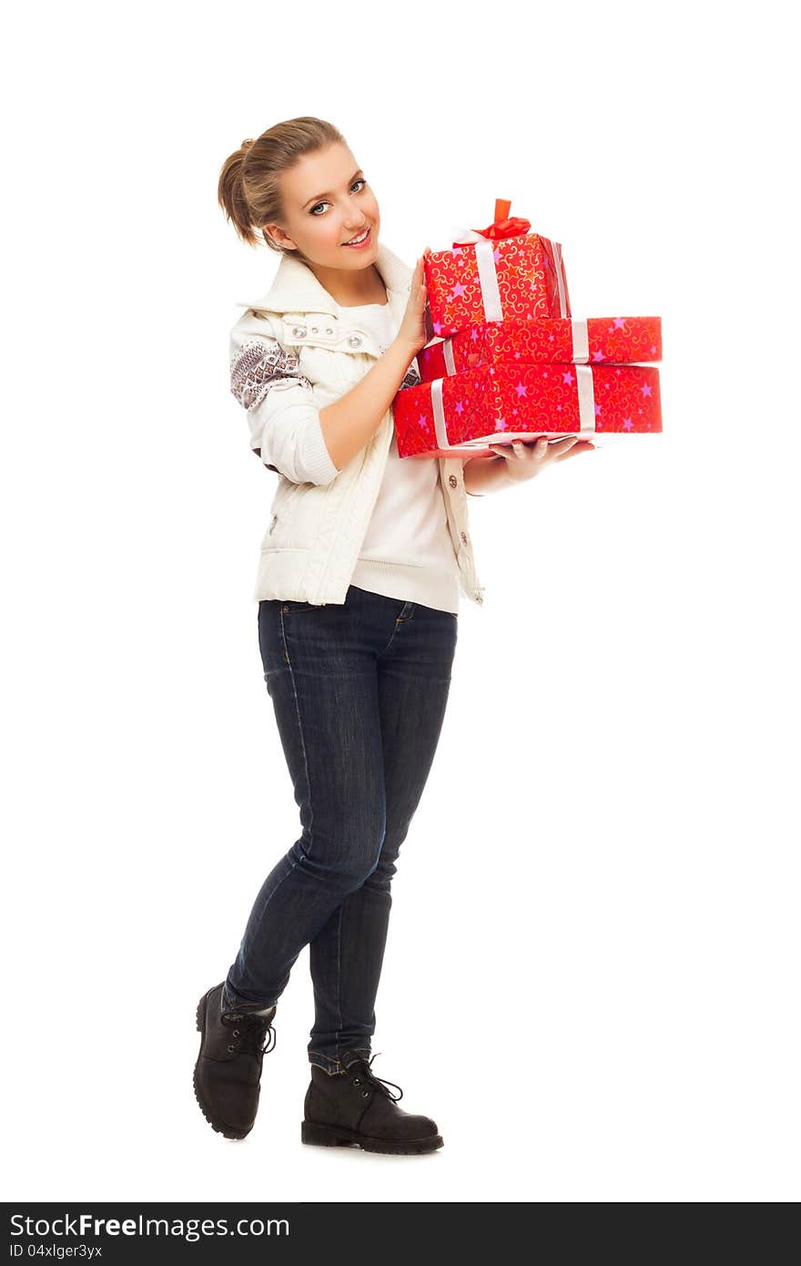 Young beautiful blond woman in white jumper with ornament and jeans holds gift red box with bow, standing is isolated on white. Young beautiful blond woman in white jumper with ornament and jeans holds gift red box with bow, standing is isolated on white