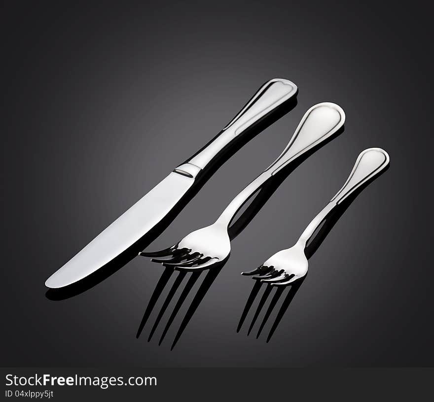 Shiny metal cutlery on dark background. Shiny metal cutlery on dark background