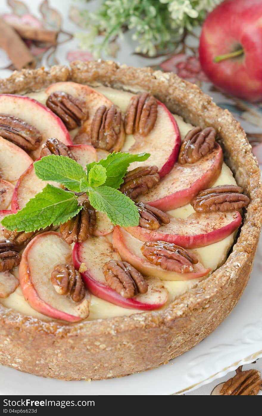 Cheesecake with apples and caramelized pecans closeup