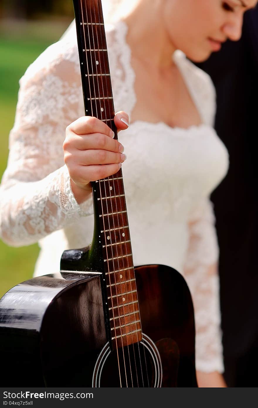 Bride in a white dress holding a hand guitar. Bride in a white dress holding a hand guitar