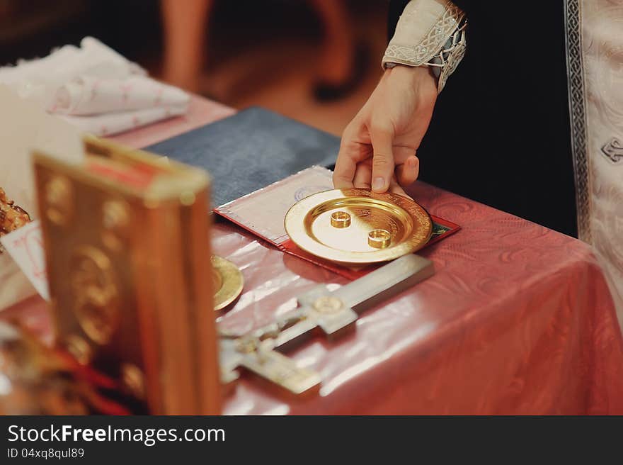 Preparations for the wedding ceremony in a church priest, wedding rings and a cross