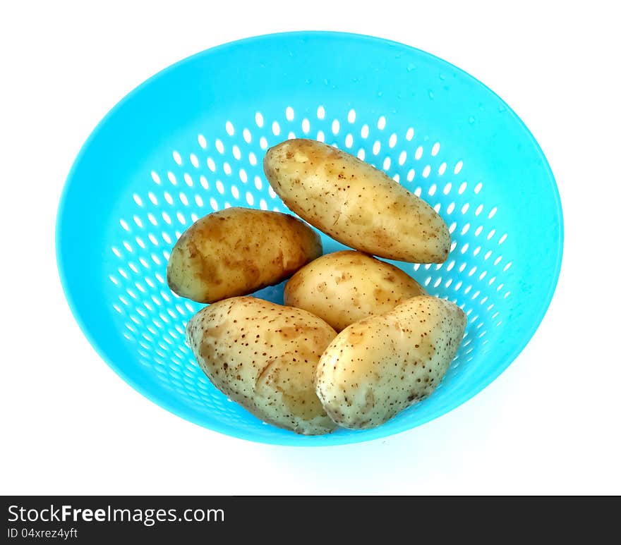 Potatoes that are cleaned to dry in a blue plastic strainer. Potatoes that are cleaned to dry in a blue plastic strainer