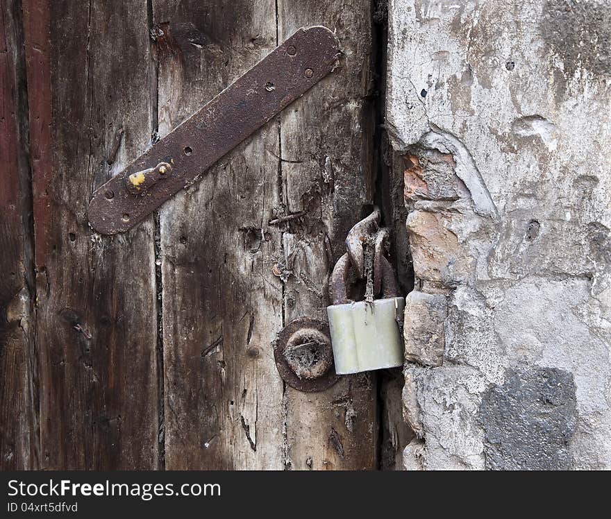 Lock on old wooden door. Very old gate.