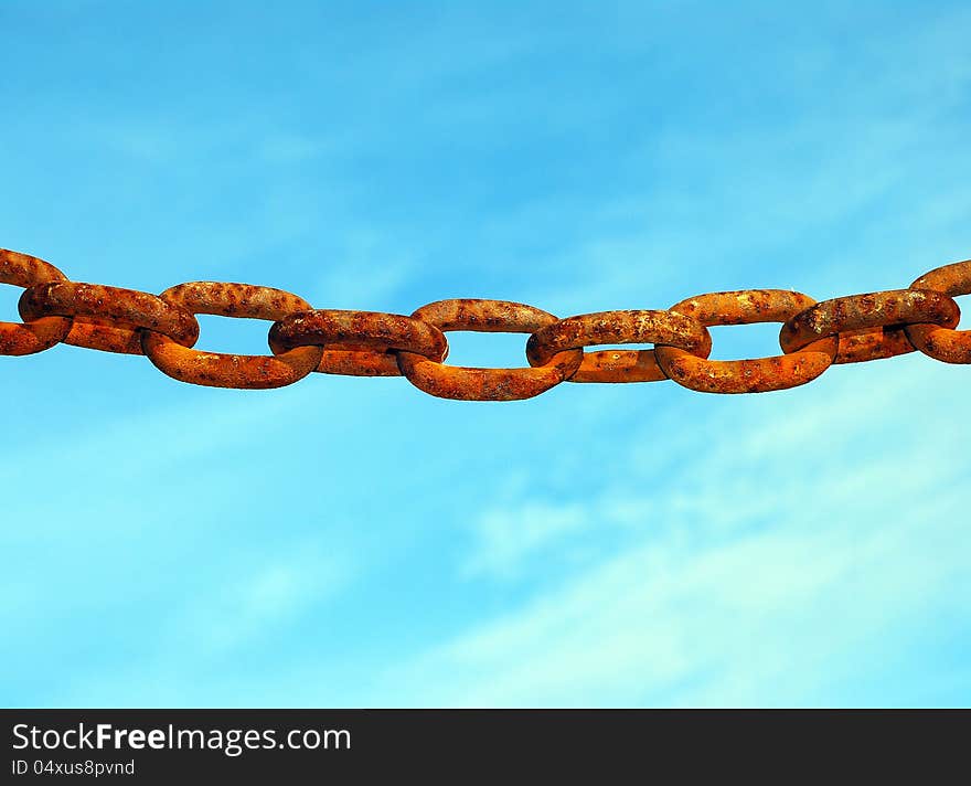 Old rusty chain hanging alone against a blue sky