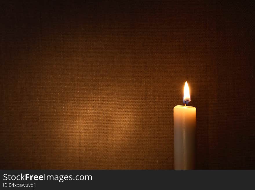 Lighting candle against canvas background with free space for text