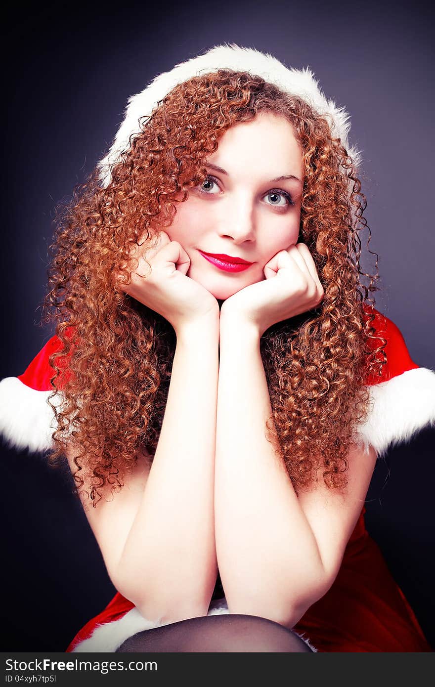 Pretty curly girl in a Santa suit