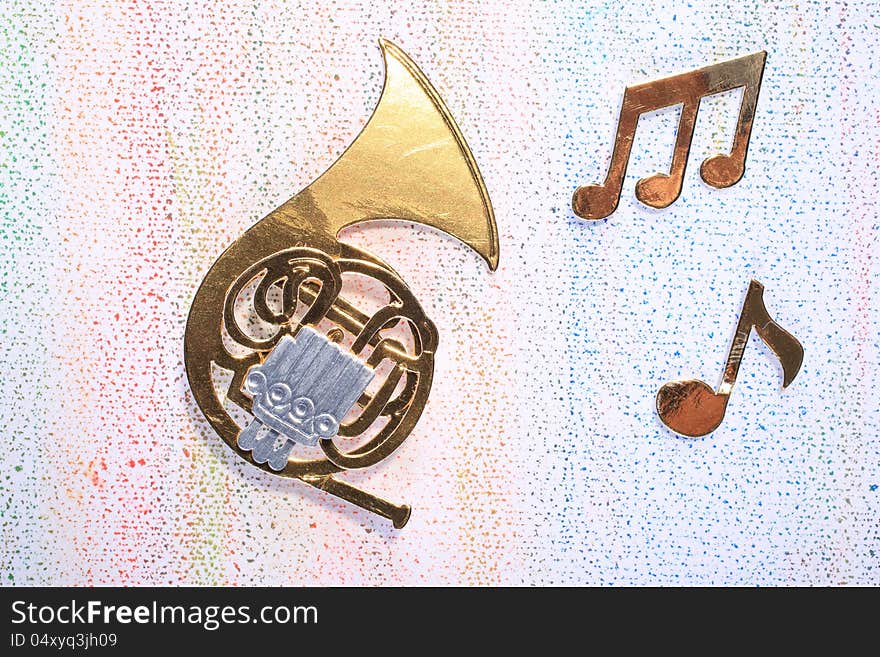 A symbolic French Horn made out of carton with musical notes on a light background. A symbolic French Horn made out of carton with musical notes on a light background