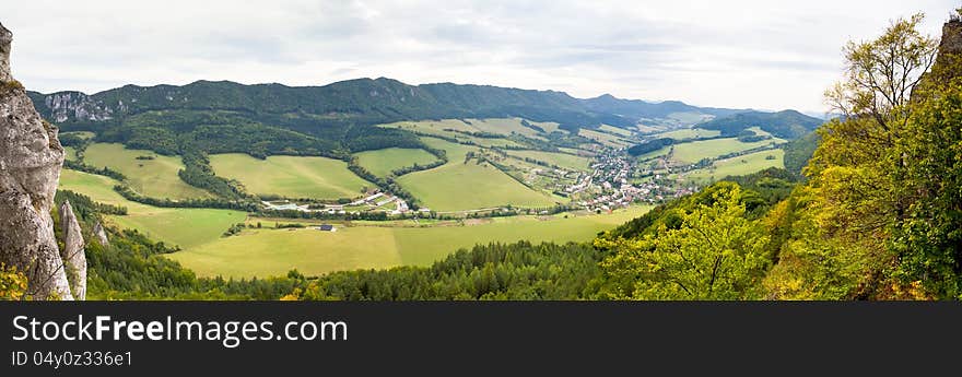 Meadow landscape in the foothills with small village in the distance. Meadow landscape in the foothills with small village in the distance