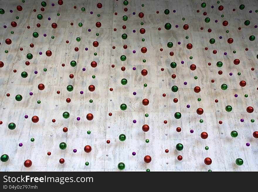 Colorful Christmas balls hanging in front of wall in business building. Colorful Christmas balls hanging in front of wall in business building