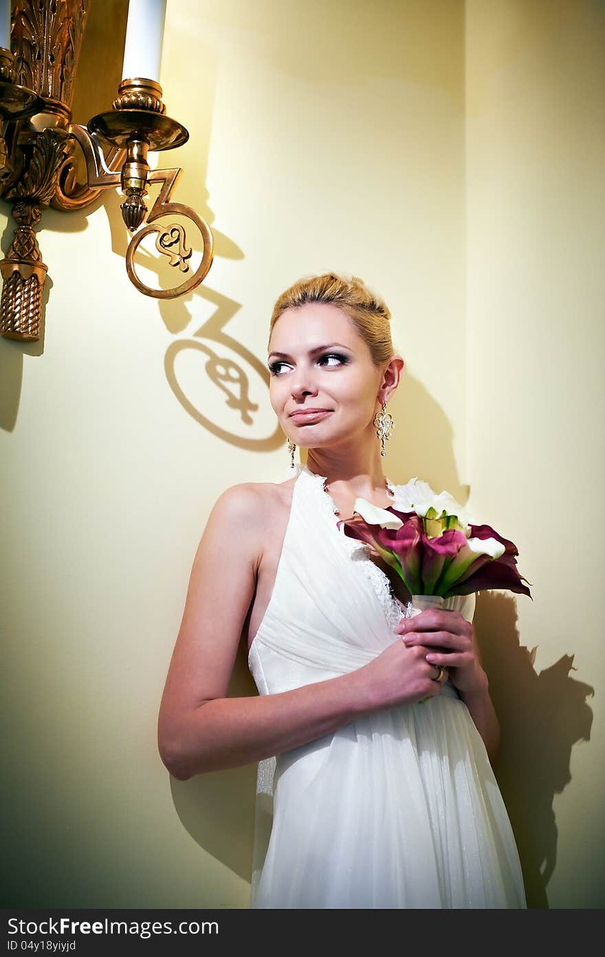 Handsome bride standing near lights candles