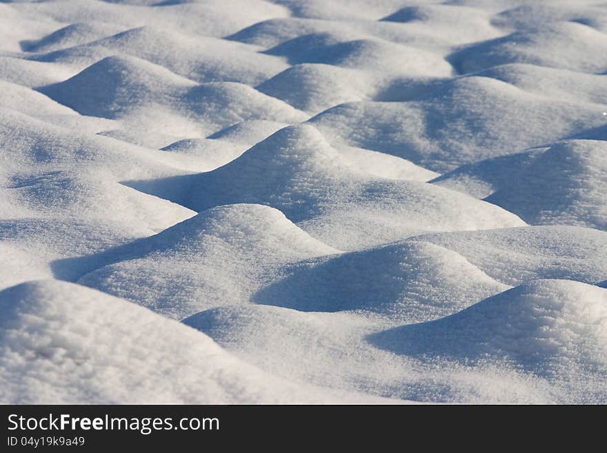 Dunes of snow in a country field