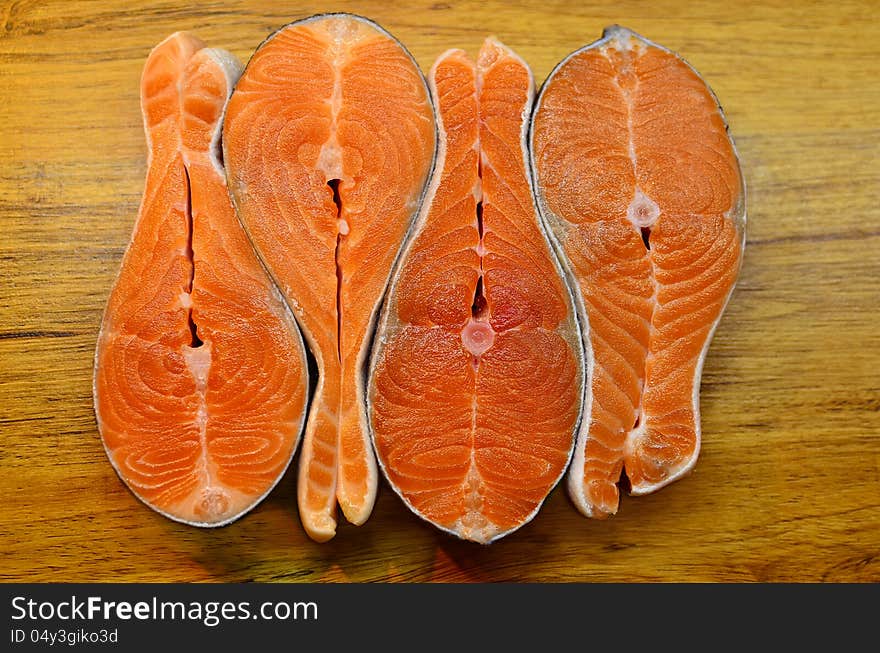 Four fish stakes on a wooden table. Close up. Four fish stakes on a wooden table. Close up