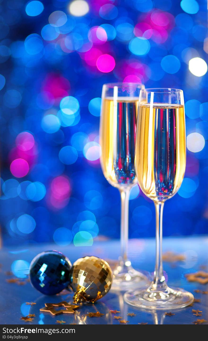 Two glasses of champagne with a Christmas decor in the background. very shallow depth of field, focus on near glass.