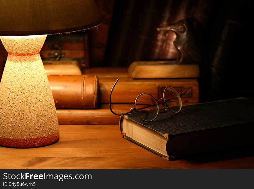 Vintage still life with old spectacles on book near desk lamp. Vintage still life with old spectacles on book near desk lamp