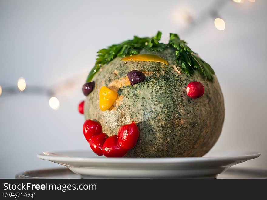 A big pumpkin head with leaves as hair and a smiling face.