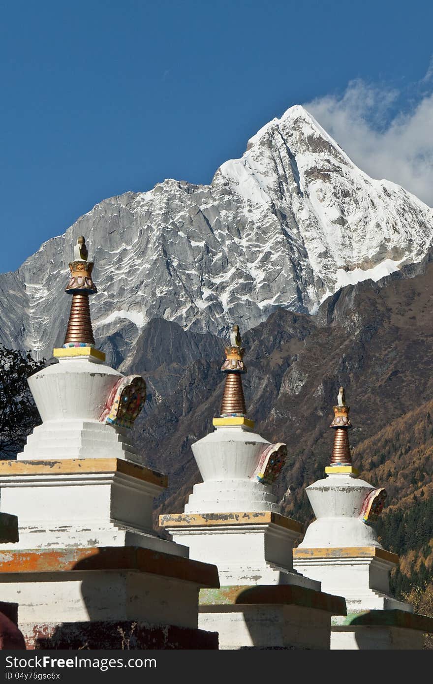 A row of Tibetan stupas at the foot of snow mountain