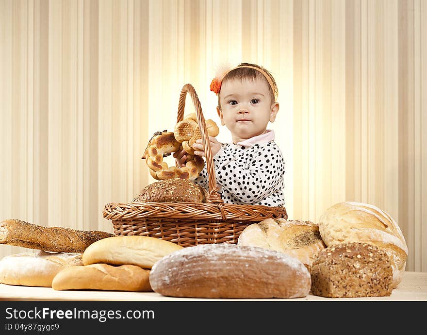 Baby girl choosing bread from basket. Baby girl choosing bread from basket