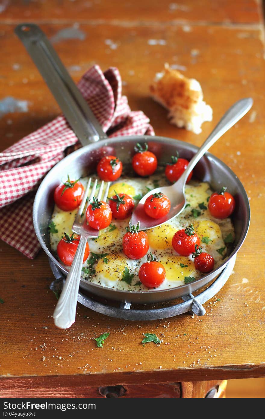 Fried quail eggs with cherry tomatoes and mozzarela cheese in a pan for breakfast. Fried quail eggs with cherry tomatoes and mozzarela cheese in a pan for breakfast