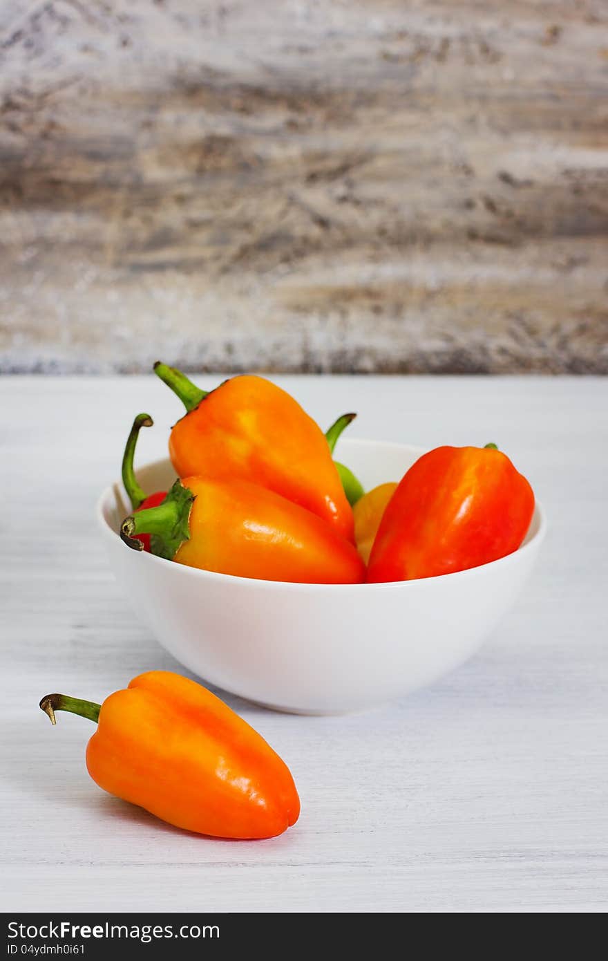 Group of ripe fresh peppers, on rusty wood background, selective focus