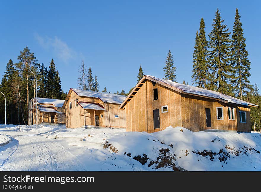 Recently constructed three country houses in wood in a sunny day against the blue sky