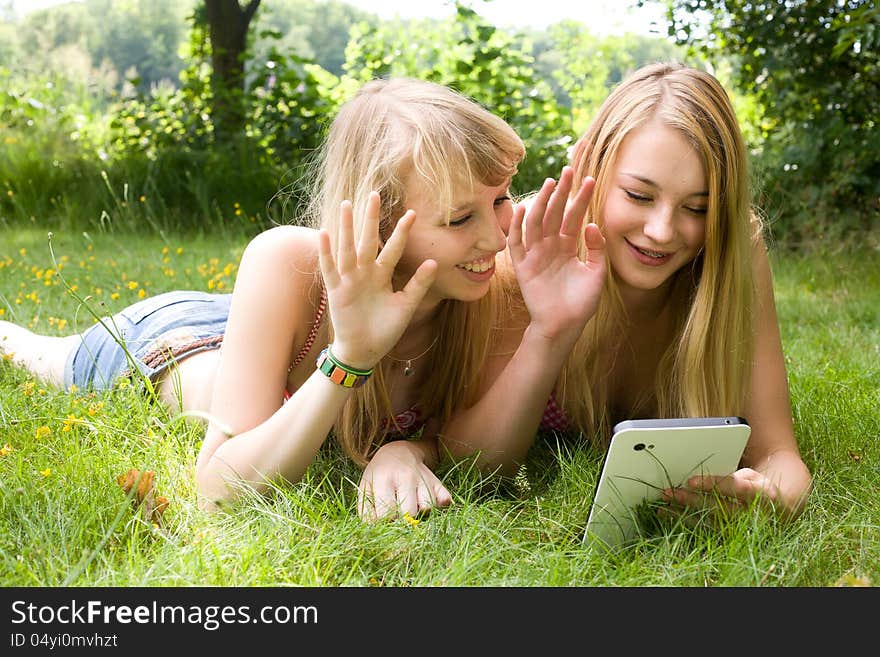 Girls waving with a tablet