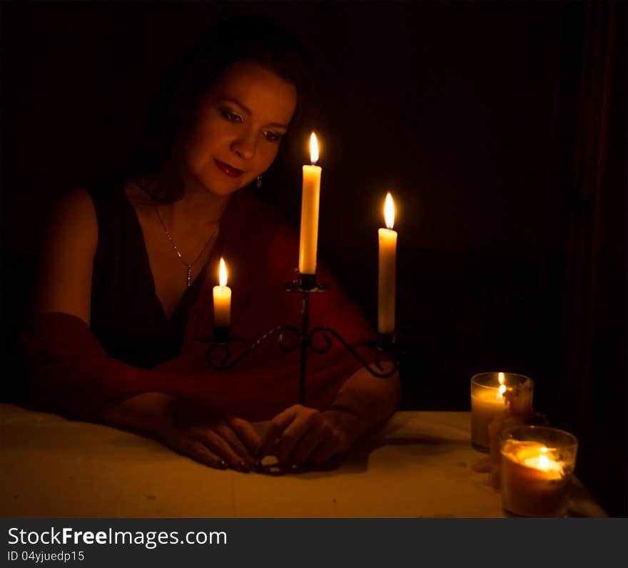 The beautiful young girl with candles on the black background. The beautiful young girl with candles on the black background