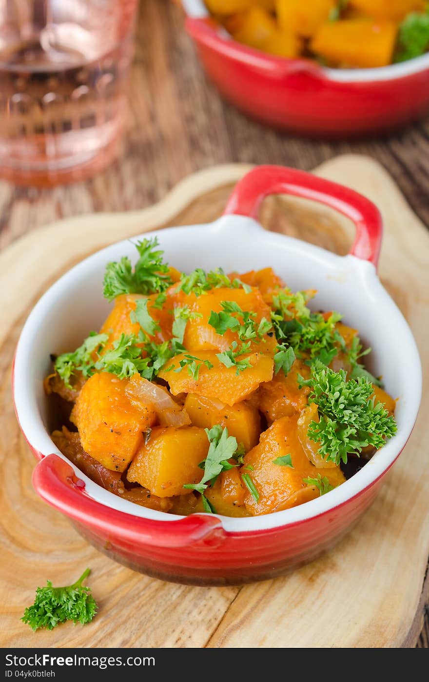 Pumpkin baked in a tomato sauce with garlic and herbs closeup