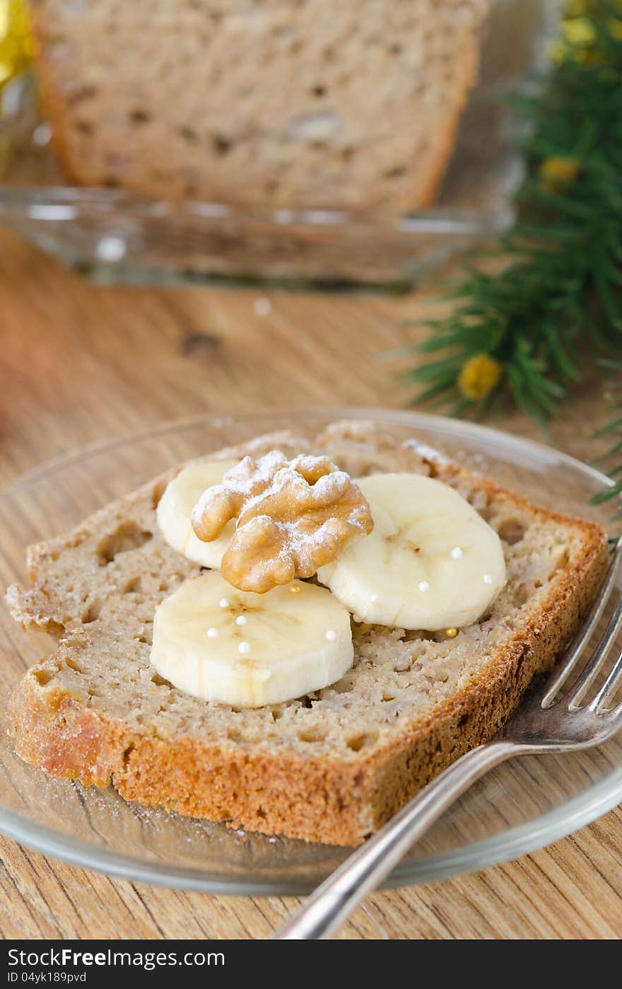 Slice of Christmas cake with banana walnut decorated slices of banana and black tea closeup