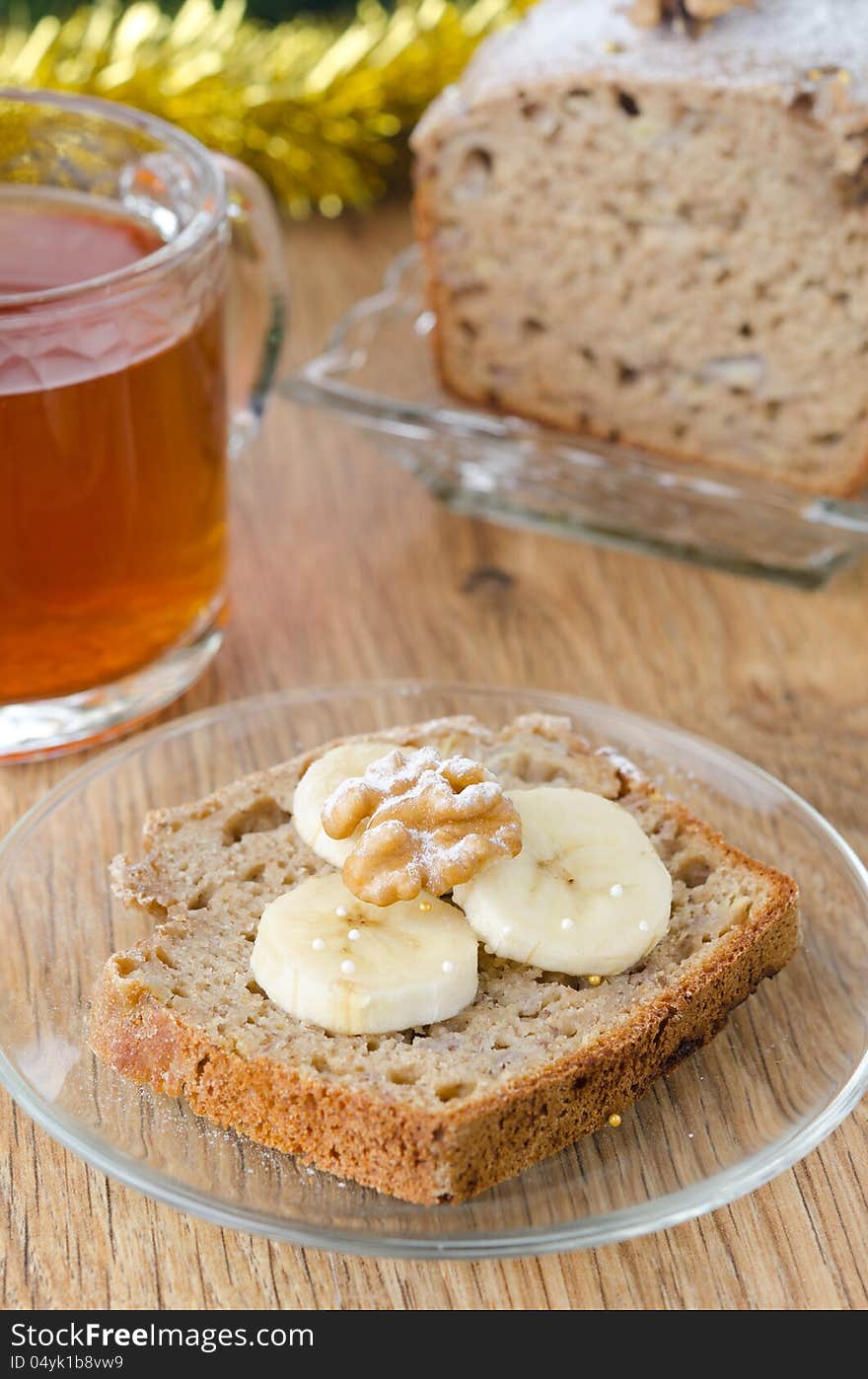 Slice of Christmas cake with banana walnut decorated slices of banana and black tea