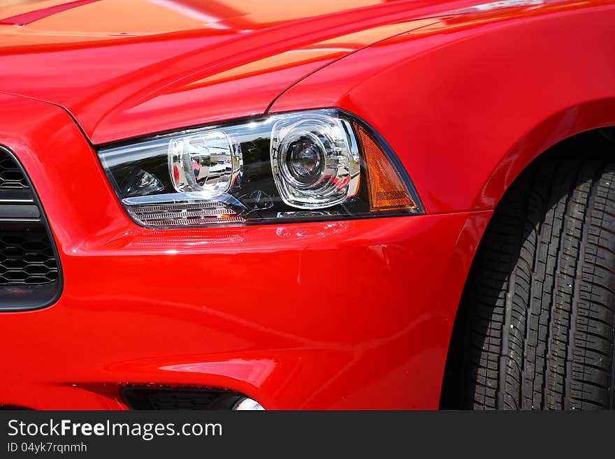 Head-light of a new, red, sport`s vehicle, closeup shot