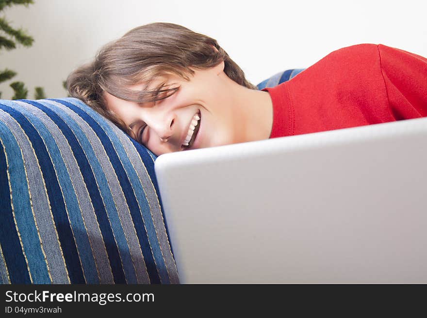 Teenage boy using laptop and laughing