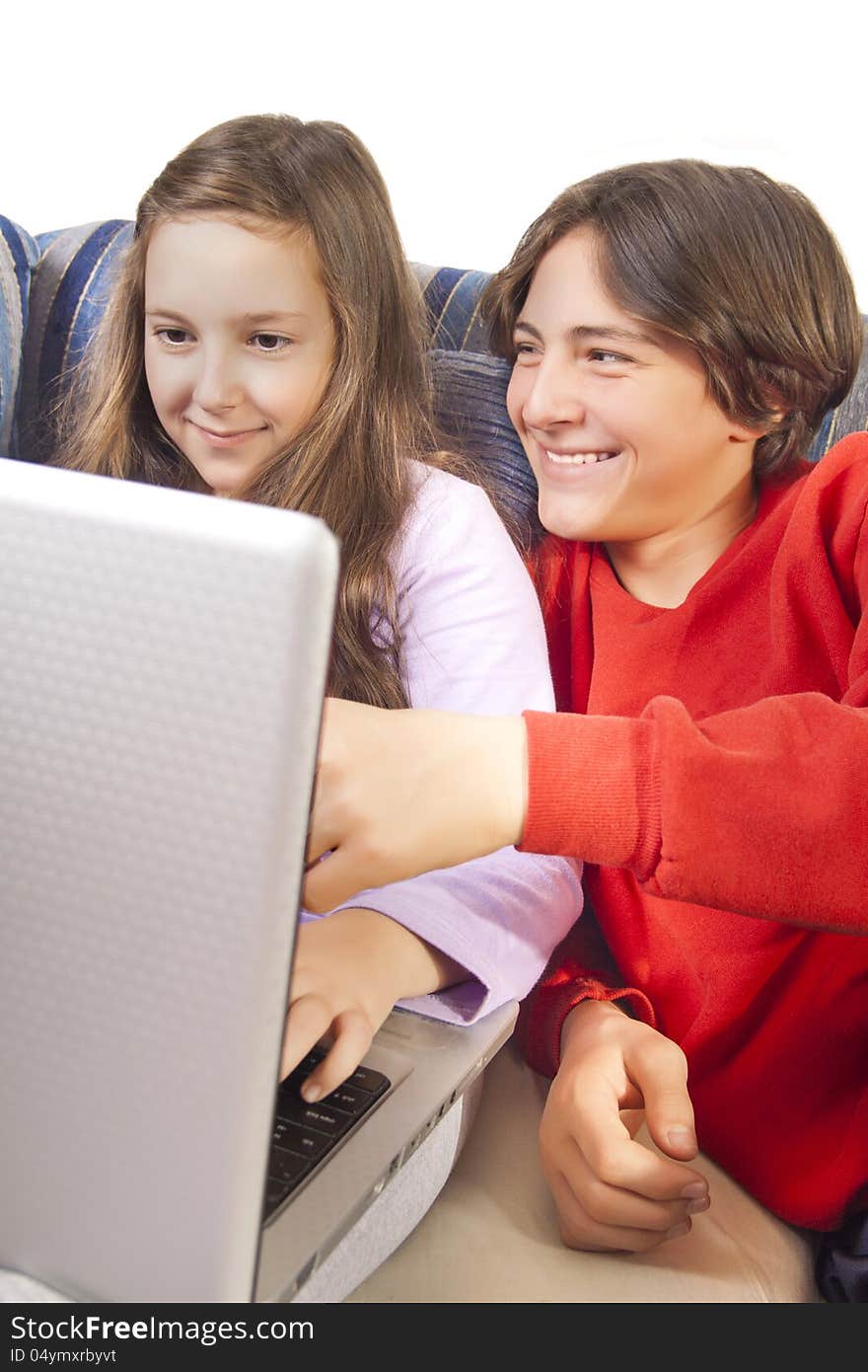 Brother and sister using laptop at home